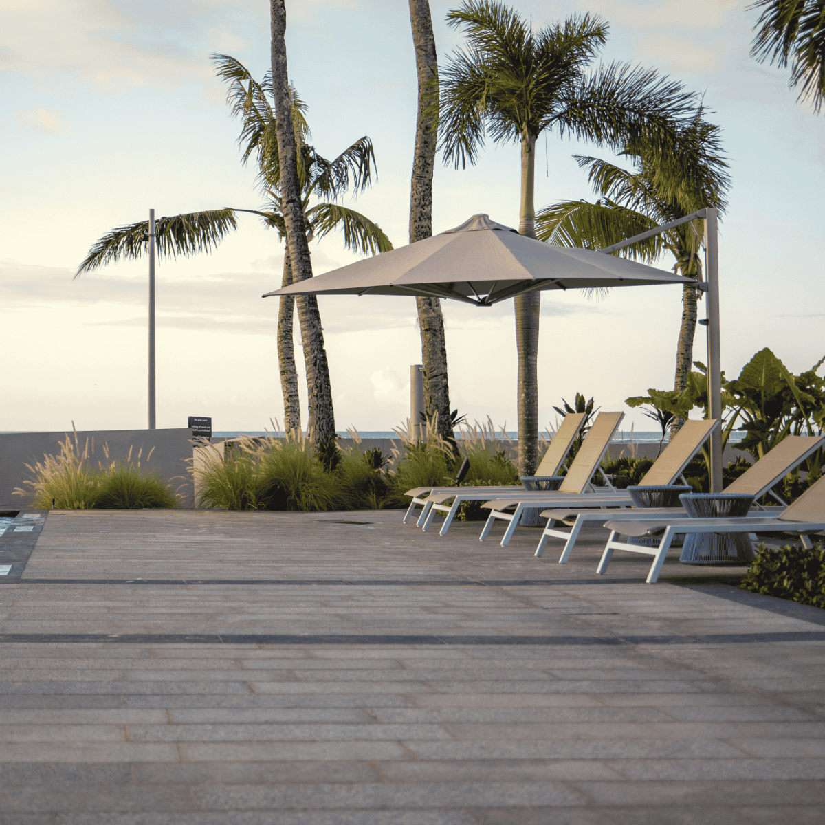 Shadowspec Serenity Rotating Cantilever umbrella with octagonal canopy at a resort pool side
