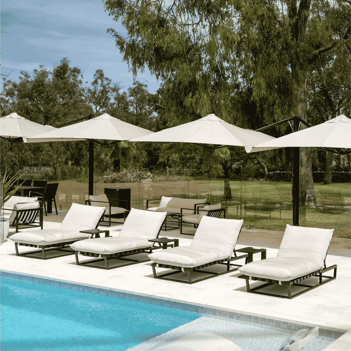 Shadowspec Unity Duo Multi-Canopy Cantilever umbrellas at a resort poolside