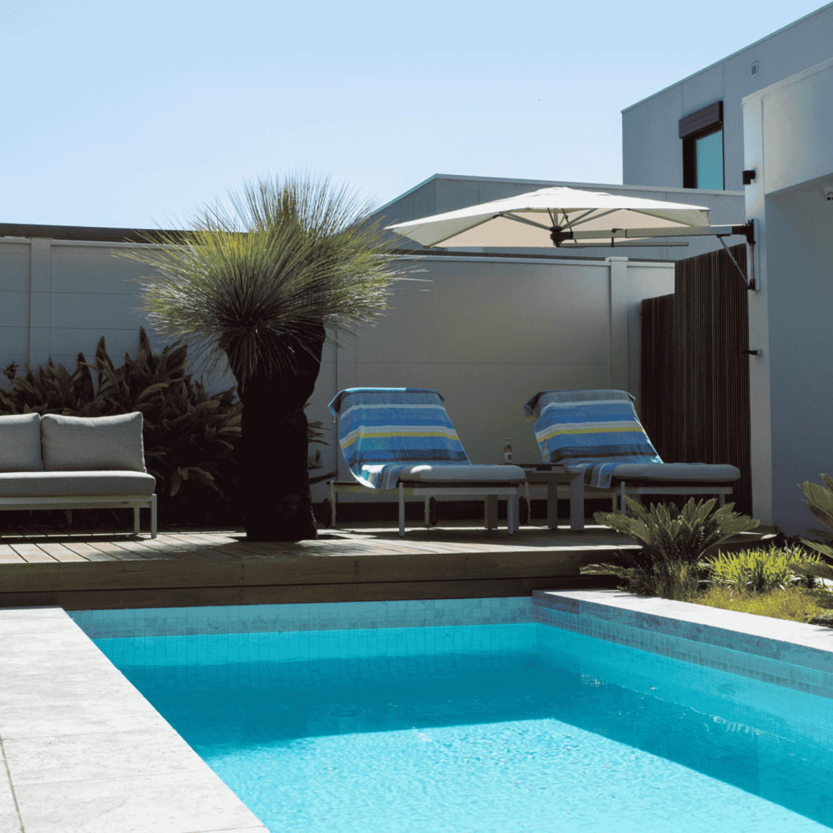 Shadowspec Retreat Wall Mounted umbrella at patio with pool