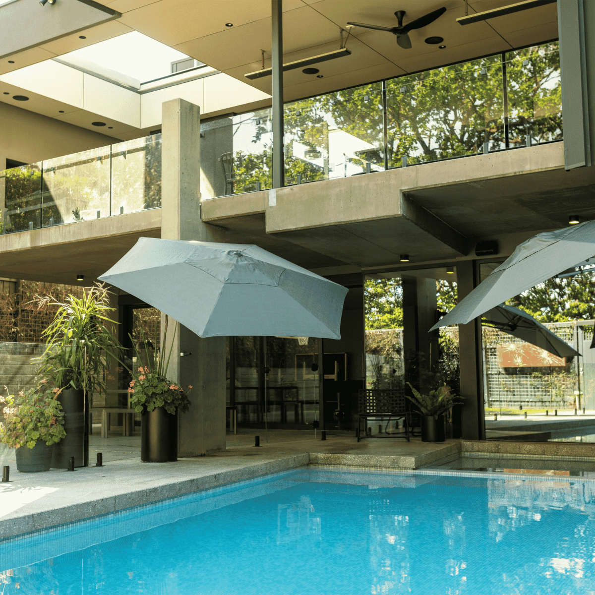 Shadowspec Retreat Wall Mounted umbrella at luxurious patio with pool