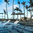 Shadowspec Serenity Rotating Cantilever umbrella with octagonal canopy around a  resort style pool