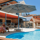 Shadowspec Serenity Rotating Cantilever umbrella with octagonal canopy at a residential pool side