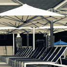 Shadowspec Unity Quattro Multi-Canopy Cantilever umbrella at a resort pool side