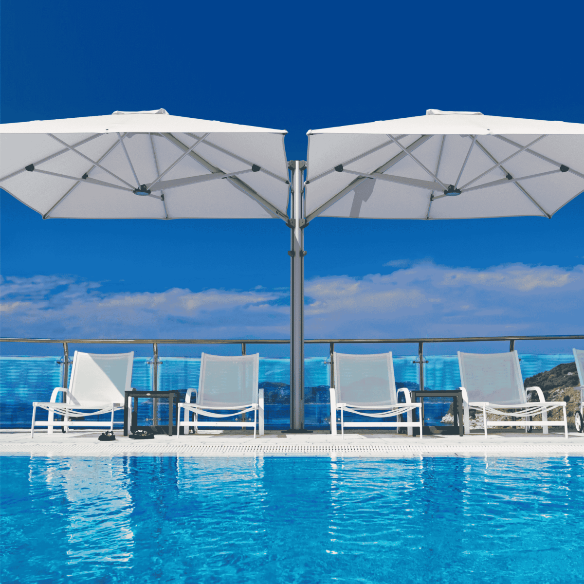 Shadowspec Unity Duo Multi-Canopy Cantilever umbrella at a poolside with clear blue sky in background