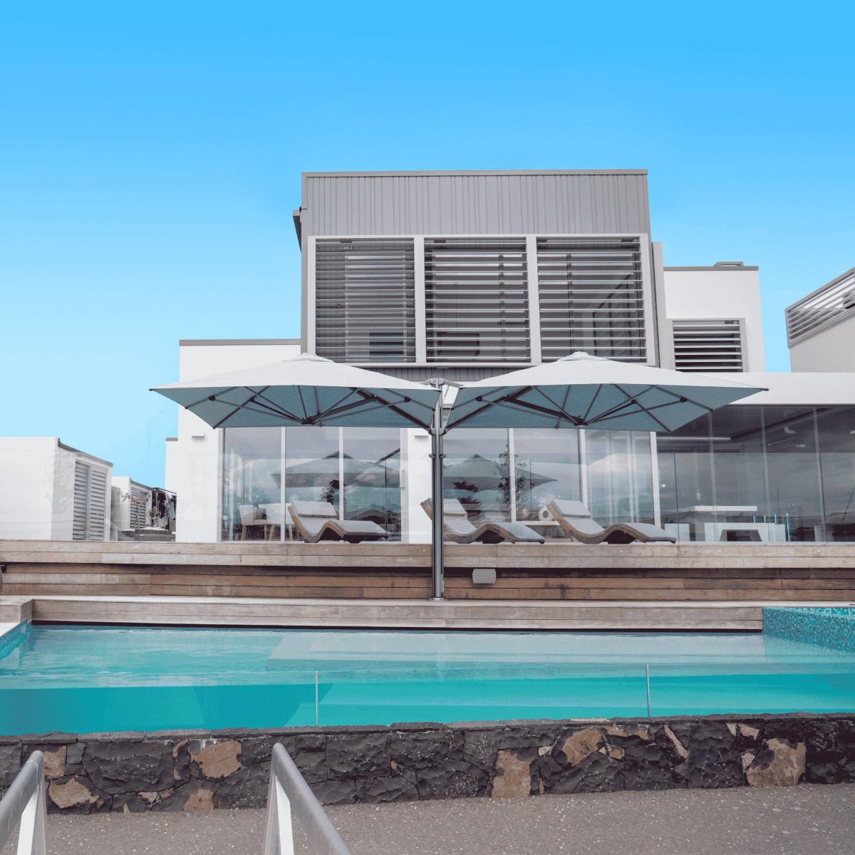 Shadowspec Unity Duo Multi-Canopy Cantilever umbrella at a poolside in residential setting
