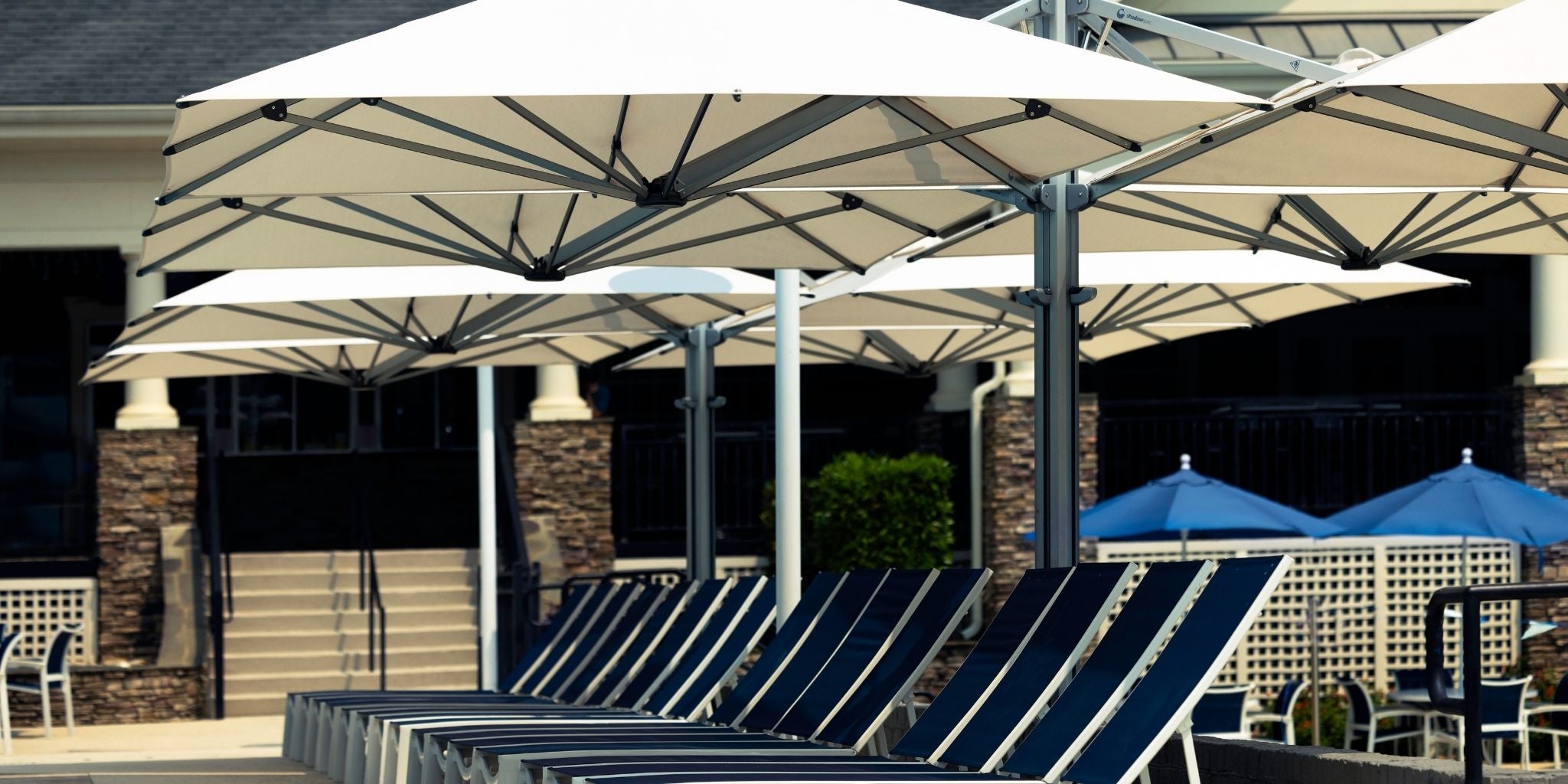 Shadowspec Unity Quattro umbrellas at a resort poolside